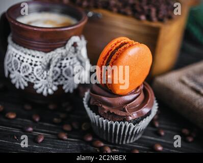 Gâteau au chocolat avec sweet hamburger. Le gâteau sur une table en bois à côté du café. Banque D'Images