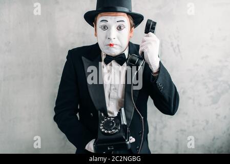 Acteur de théâtre de pantomime avec masque maquillage rétro avec téléphone. Artiste de comédie en litige, des gants et un chapeau Banque D'Images