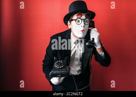 Acteur de théâtre Mime d'effectuer avec l'ancien téléphone. Pantomime comique artiste en costume, chapeau et gants Banque D'Images