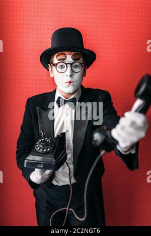 Acteur de théâtre Mime d'effectuer avec l'ancien téléphone. Pantomime comique artiste en costume, chapeau et gants Banque D'Images