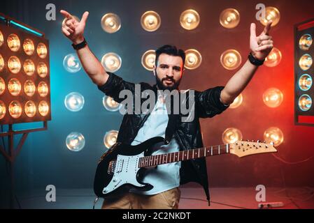 Musican Male solo avec guitare électro sur la scène avec les décors de lumières. Music Entertainment. Banque D'Images