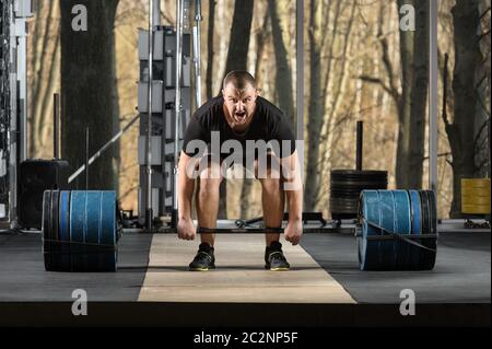 Deadlift tentative. Jeune homme essayant de soulever de lourdes barbell Banque D'Images