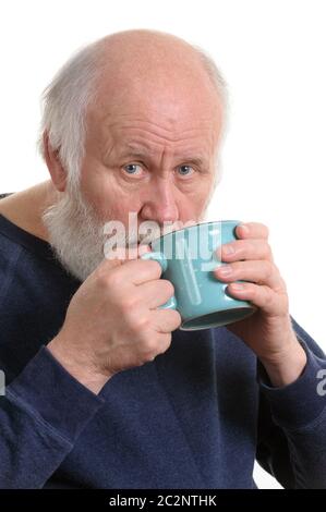 Homme âgé buvant dans une tasse, isolated on white Banque D'Images