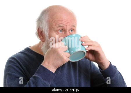 Homme âgé buvant dans une tasse, isolated on white Banque D'Images