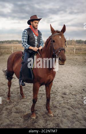 Vêtements en cuir de cow-boy riding a horse on farm, dans l'ouest. Vintage homme à cheval, la culture américaine Banque D'Images