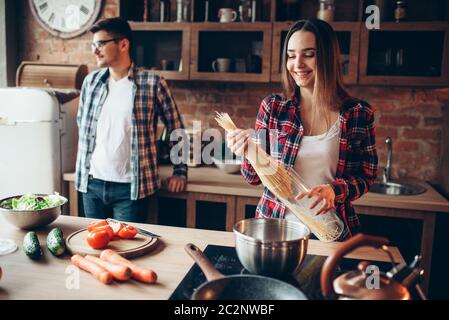 Couple cooking fresh Vegetable salad et spaghettis sur la cuisine. Le régime alimentaire la préparation des aliments. Couple prépare un dîner romantique, style de vie sain Banque D'Images