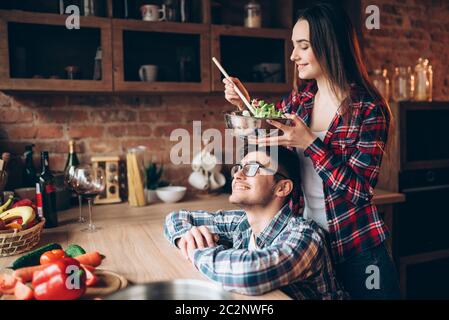 Heureux couple salade de légumes cuisson ensemble, dîner romantique en préparation. Prépare des aliments sains de la famille sur la cuisine Banque D'Images