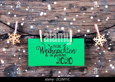 Label vert avec calligraphie allemand Frohe Weihnachten und ein 2020 Glueckliches veut dire Joyeux Noël et une Bonne 2020. Corde avec Ornamen de Noël. Rus Banque D'Images