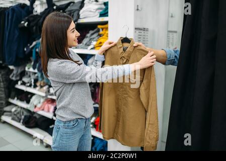 Couple shirts dans d'essayage, family shopping in clothes store. Les clients en boutique, les acheteurs dans le marché Banque D'Images