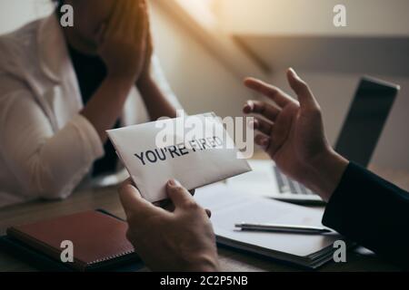 Le Manager masculin parle ou explique qu'il faut licencier l'employé tout en lui donnant une enveloppe de démission. Banque D'Images