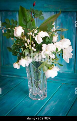 Un bouquet de mariage de lys de la vallée et de roses blanches. Fond en bois sarcelle Banque D'Images