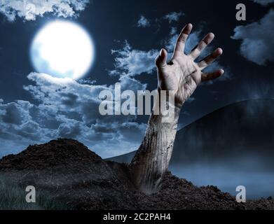 La main de Zombie qui sort de sa tombe. Pleine lune, le soir de l'halloween Banque D'Images