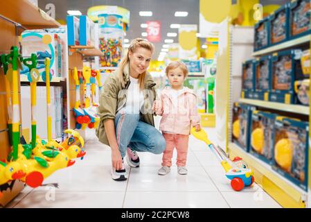 M re avec petite fille dans le magasin pour enfants. Maman et