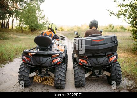 Deux vtt dans casques, vue arrière. Freeride sur quad, sport extrême et de voyage, aventure estivale quadbike Banque D'Images