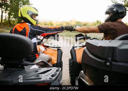 Deux casques de VTT en hits fists pour la bonne chance avant d'équitation tout terrain extrême, vue de dos. Freeride sur quad, quadbike aventure d'été Banque D'Images