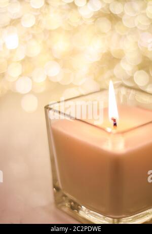 Bougie aromatique sur fond doré de Noël et de paillettes du nouvel an, décoration luxueuse de la maison de Saint Valentin et marque de la saison des fêtes Banque D'Images