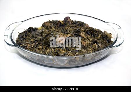Ghormeh est dérivé du kavurmak turc et signifie braisé, tandis que sabzi est le mot perse pour les herbes . Ghormeh sabzi verre plaque fond blanc . Banque D'Images