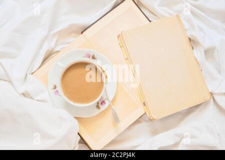 Tasse de cappuccino sur un livre et une feuille blanche Banque D'Images