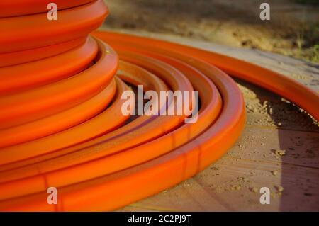 Un rouleau de câbles orange. Construction de l'installation de fibres optiques. Banque D'Images