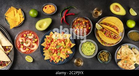 Un panorama de la cuisine mexicaine, de nombreux plats de la cuisine du Mexique, plat, en hauteur, sur fond noir. Nachos, guacamo Banque D'Images