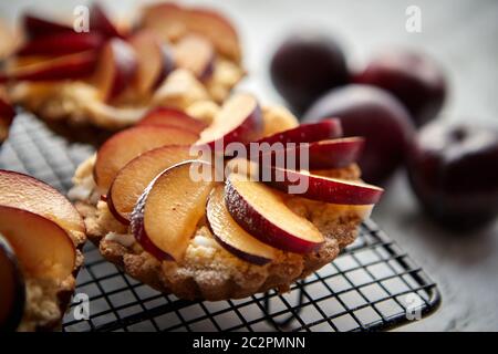 Tartelettes crumble fait maison avec des tranches de prune mis sur la cuisson grill fer Banque D'Images