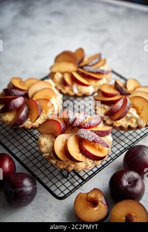 Tartelettes crumble fait maison avec des tranches de prune mis sur la cuisson grill fer Banque D'Images