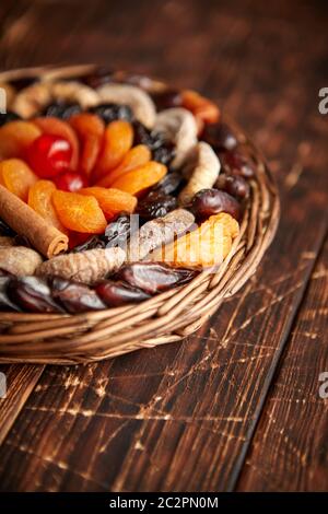 Mélange de fruits secs dans un petit panier en osier sur la table en bois Banque D'Images