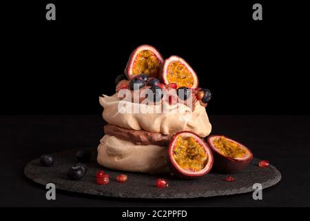 Pavlova dessert mélanger des fruits sur fond sombre. Gâteau culinaire manger. Banque D'Images