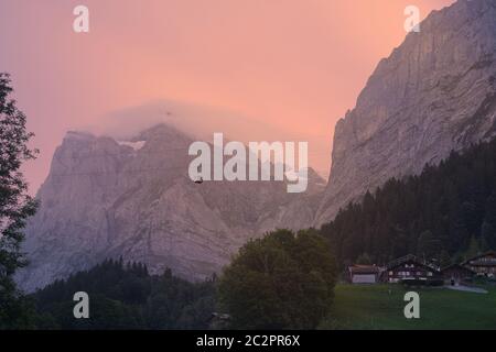 Beau lever de soleil à Grindelwald dans les Alpes bernoises, Suisse. Un ciel pastel et des wafts de brouillard sur les sommets de montagne. Banque D'Images