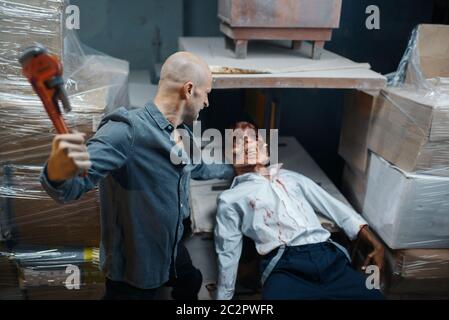 Un homme avec une clé à pipe tue des zombies, une chasse mortelle. Horreur en ville, attaque de craies effrayantes, apocalypse doomsday, monstre sanglant Banque D'Images