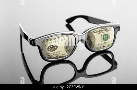 Lunettes noires avec des dollars au lieu de lentilles sur gris Banque D'Images