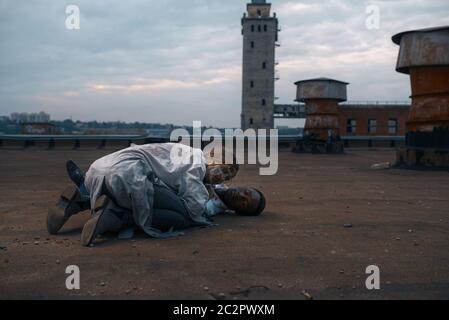 Couple zombie sur le toit d'un bâtiment abandonné, poursuite mortelle. Horreur en ville, attaque de craies effrayantes, apocalypse Banque D'Images