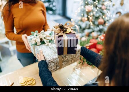 Vendeur service d'emballage cadeau de noël client donne à fort. L'acheteur a commandé un paquet de présents, d'emballage de fête Banque D'Images