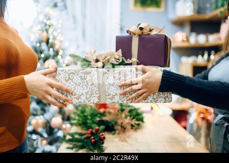 Vendeur service d'emballage cadeau de noël client donne à fort. L'acheteur a commandé un paquet de présents, d'emballage de fête Banque D'Images