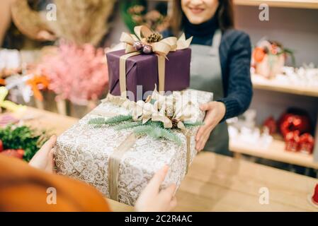 Vendeur service d'emballage cadeau de noël client donne à fort. L'acheteur a commandé un paquet de présent Banque D'Images