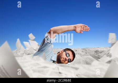 Homme dans des lunettes natation dans des papiers Banque D'Images