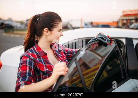 Après lavage automobile lingettes femme sur le libre-service de lavage de voiture. Dame véhicule nettoyage Banque D'Images