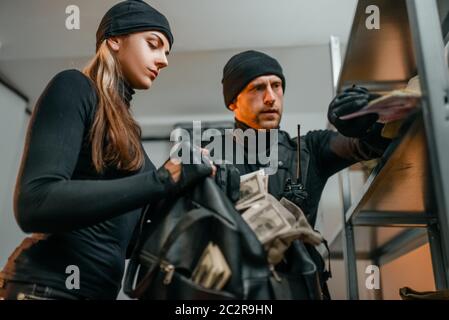 Cambriolage de banque du siècle, deux voleurs en uniforme noir vole de l'argent de la voûte. Profession criminelle, concept de vol Banque D'Images