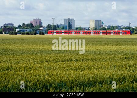 Heidelberg, Allemagne. 18 juin 2020. Un train régional passe devant un champ dans la région de Wolf Garden, l'un des deux endroits possibles pour le nouveau centre d'arrivée des réfugiés. Un nouveau quartier sera construit sur le site du centre d'arrivée existant dans l'ancien village américain Patrick-Henry. Le centre d'arrivée doit donc se déplacer vers un autre emplacement. Credit: Uwe Anspach/dpa/Alamy Live News Banque D'Images