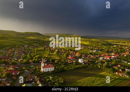 Ciel dramatique avec orageux sur le petit village de Transylvanie. Banque D'Images