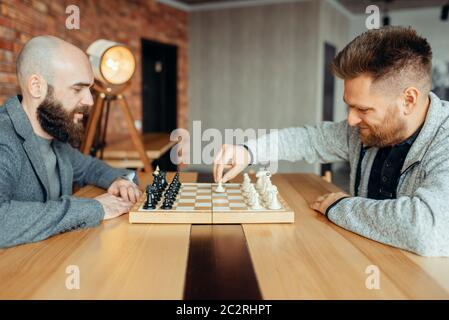 Les joueurs d'échecs de commencer à jouer, le premier coup. Deux chessplayers commencer le tournoi intellectuelle à l'intérieur. Sur l'échiquier en bois, stratégie gam Banque D'Images