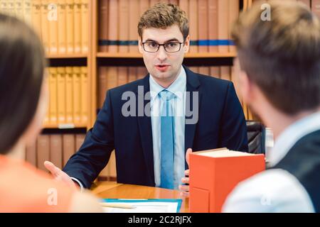 Notaire conseillant le couple sur le mariage dans son bureau Banque D'Images