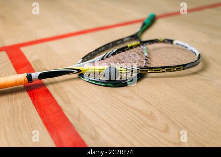 Vue rapprochée de l'équipement de jeu de squash. Les raquettes et la balle sur le sol, à l'intérieur du club de formation Banque D'Images