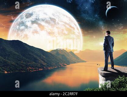 Businessman standing on the edge dans la nuit et à la grande lune Banque D'Images