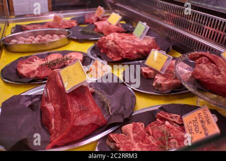 Coupes de viande de veau crues dans un comptoir froid avec étiquettes de prix prêtes à être vendues dans la boutique du boucher. Banque D'Images