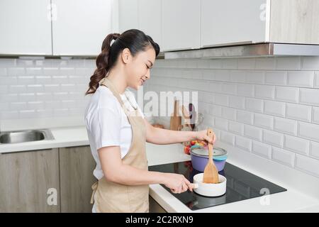 Femme de cuisine dans la cuisine avec cuillère en bois Banque D'Images