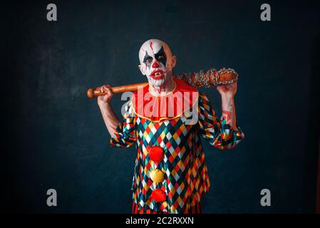 Crazy clown sanglant avec batte de baseball. Homme avec un miroir en costume halloween, maniac Banque D'Images