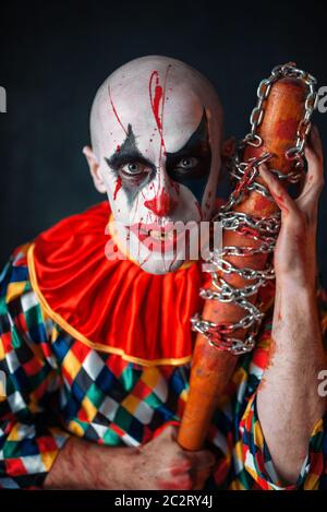 Crazy clown sanglant avec batte de baseball. Homme avec un miroir en costume halloween, maniac Banque D'Images