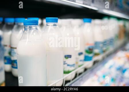 Rangée de bouteilles de lait dans le réfrigérateur, magasin d'alimentation, personne. La production laitière au supermarché Banque D'Images