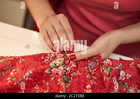 tailleur femme ragoûts robe rouge. Travailler sur mesure dans son atelier de travail sur mesure Banque D'Images